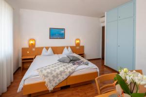 una camera da letto con un grande letto con due tavoli di Hotel Rondinella Locarno a Locarno