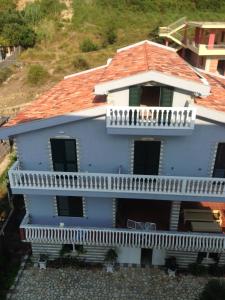 una casa azul con balcón en la parte superior en Villa George, en Orikum