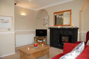 a living room with a fireplace and a tv at Aelfor Cottage in Barmouth in Barmouth