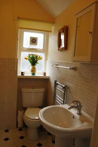 La salle de bains est pourvue de toilettes, d'un lavabo et d'une fenêtre. dans l'établissement Aelfor Cottage in Barmouth, à Barmouth