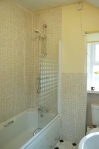 La salle de bains est pourvue d'une baignoire et de toilettes. dans l'établissement Aelfor Cottage in Barmouth, à Barmouth