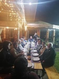 un grupo de personas sentadas alrededor de una mesa larga en Valle el Abra Ralún Lodge, en Puerto Varas