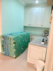eine Küche mit grünem Koffer in der Ecke in der Unterkunft Puncak Villa 10-20pax in Kuala Kangsar