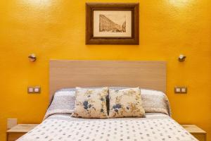 a bedroom with a bed with a yellow wall at Zona Doctor Peset - B in Valencia