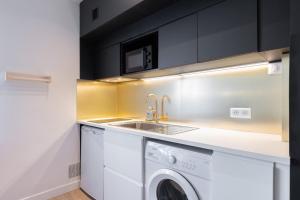 a kitchen with a sink and a washing machine at Appartement rénové en 2023 à 10 min de Lille in Marquette-lès-Lille +12 photos