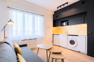 a living room with a couch and a washing machine at Appartement rénové en 2023 à 10 min de Lille in Marquette-lès-Lille