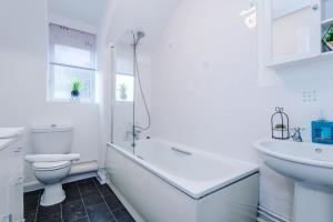 Baño blanco con aseo y lavamanos en Charming 2Bed Retreat in Historic Coventry, en Coventry