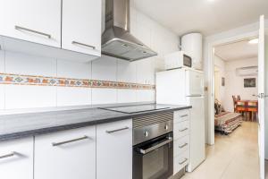 a kitchen with white cabinets and a stove at Zona Garbí in Valencia