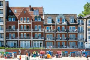 pessoas na praia em frente a um grande edifício em Nordland Appartements - Wohnung Lolland em Wyk auf Föhr