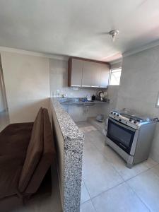 uma cozinha com um balcão e um fogão em Edif Elias Pinto Coelho, apto.404 em Guarapari