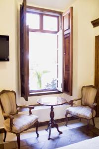a room with two chairs and a table and a window at Casa Eugenia Hotel in Morelia