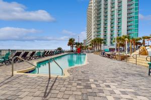 a swimming pool with chairs and a building at Oceans One Resort Unit 403 in Myrtle Beach
