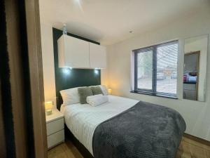 a small bedroom with a bed and a window at Modern 1 Bedroom self contained apartment in Welwyn Garden City