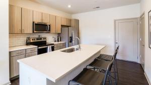 eine Küche mit einer Theke und 2 Stühlen darin in der Unterkunft Landing Modern Apartment with Amazing Amenities (ID6626X61) in Fishers