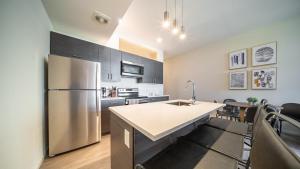 a kitchen with a stainless steel refrigerator and cabinets at Landing Modern Apartment with Amazing Amenities (ID4770X14) in Cleveland