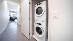 a washer and dryer in a room with a hallway at Landing Modern Apartment with Amazing Amenities (ID4770X14) in Cleveland