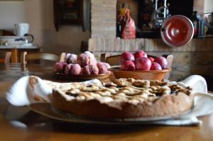 un pastel en una mesa con dos cuencos de fruta en Agriturismo Fattoria di Statiano, en Pomarance