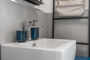 um lavatório branco com dois óculos azuis em The Tropical Corner by Rentbeat em Roma