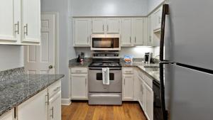 een keuken met witte kasten, een fornuis en een magnetron bij Landing Modern Apartment with Amazing Amenities (ID2690X00) in Nashville