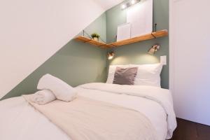 two beds in a small room with white sheets at Lille Gares - Nice equipped apartment in Lille