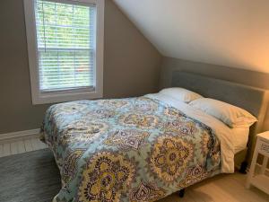 a bedroom with a bed with a quilt and a window at Hangout House play, work, and visit in Nashville