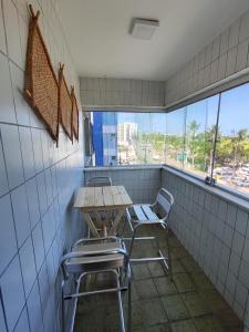 a table and chairs in a room with a window at Temporada Beira-Mar Maceió in Maceió