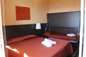 Habitación de hotel con 2 camas con sábanas rojas en Hotel Palace, en Varazze