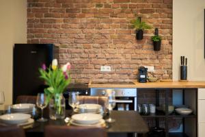 a kitchen with a table and a brick wall at Central Apartment - Linienstraße in Berlin