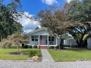 a white house with a tree in the front yard at The Cottage in Wilmington