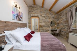 a bedroom with a large white bed in a stone wall at Villa Palazza in Pazin +60 photos