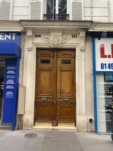 una gran puerta de madera en el lateral de un edificio en logement cosy et moderne proche de toute commodité en París