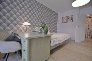 a bedroom with a bed and a desk with a table sidx sidx sidx at Apartamenty Bryza - Debina in Świnoujście