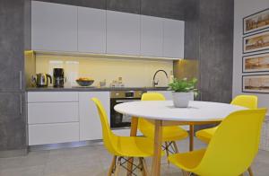 シフィノウイシチェにあるApartamenty Bryza - Debinaのキッチン(テーブル、黄色い椅子付)