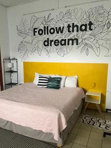 Un dormitorio con una cama y un seguimiento de ese signo de sueño en la pared en The cool house Habitación 2, en Ciudad Guzmán