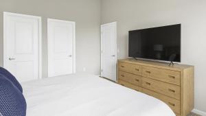 Landing Modern Apartment with Amazing Amenities (ID7649X87) في دبلن: غرفة نوم مع تلفزيون على دولاب خشبي