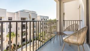 d'un balcon avec deux chaises et une table et certains bâtiments dans l'établissement Landing Modern Apartment with Amazing Amenities (ID7569X30), à Fort Myers