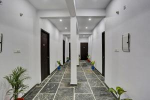 um corredor com vasos de plantas num edifício em Collection O Hotel RBS em Lucknow