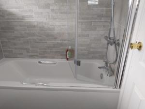 a shower with a glass door next to a sink at Luxurious Beautiful Home Ideal for longer stay in Stanford-le-Hope