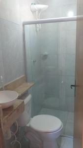 a bathroom with a toilet and a glass shower at Pousada LuMar Maragogi in Maragogi