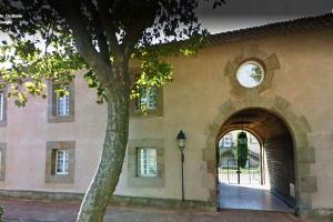 un reloj al lado de un edificio con un árbol en Château Winery la Batisse le minervois, en Laredorte
