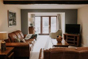 a living room with a couch and a tv at Pattys Farm Barn in Cockerham