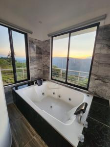 y baño con bañera grande y ventanas. en Esmeralda DELUXE, en San Gil