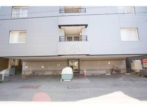 un gran edificio blanco con aparcamiento en Haimu Shanzerize 7,12 - Vacation STAY 11291, en Sapporo