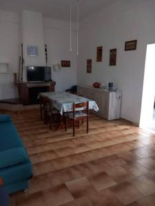 - un salon avec une table, des chaises et une télévision dans l'établissement Villa Giusy, à Campomarino