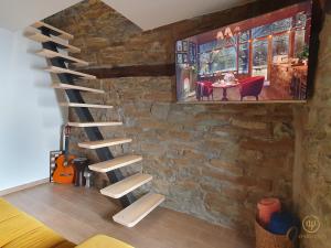 una escalera de madera en una habitación con una pared de ladrillo en Istrian Perfect Life, en Šmarje