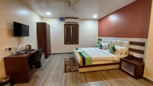 a bedroom with a bed and a television in it at Goroomgo New Paradise Industrial Estate Bhubaneswar in Bhubaneshwar
