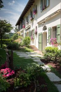 a building with green doors and flowers in a yard at Casa Sunset Hill Bologna in Bologna