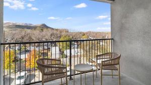 two chairs and a table on a balcony with a view at Landing Modern Apartment with Amazing Amenities (ID2951X44) in West Valley City