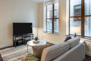 a living room with a couch and a television at Landing Modern Apartment with Amazing Amenities (ID1787X82) in Detroit