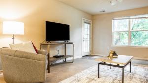 - un salon avec une télévision, une chaise et une table dans l'établissement Landing Modern Apartment with Amazing Amenities (ID9647X69), à Newport News
